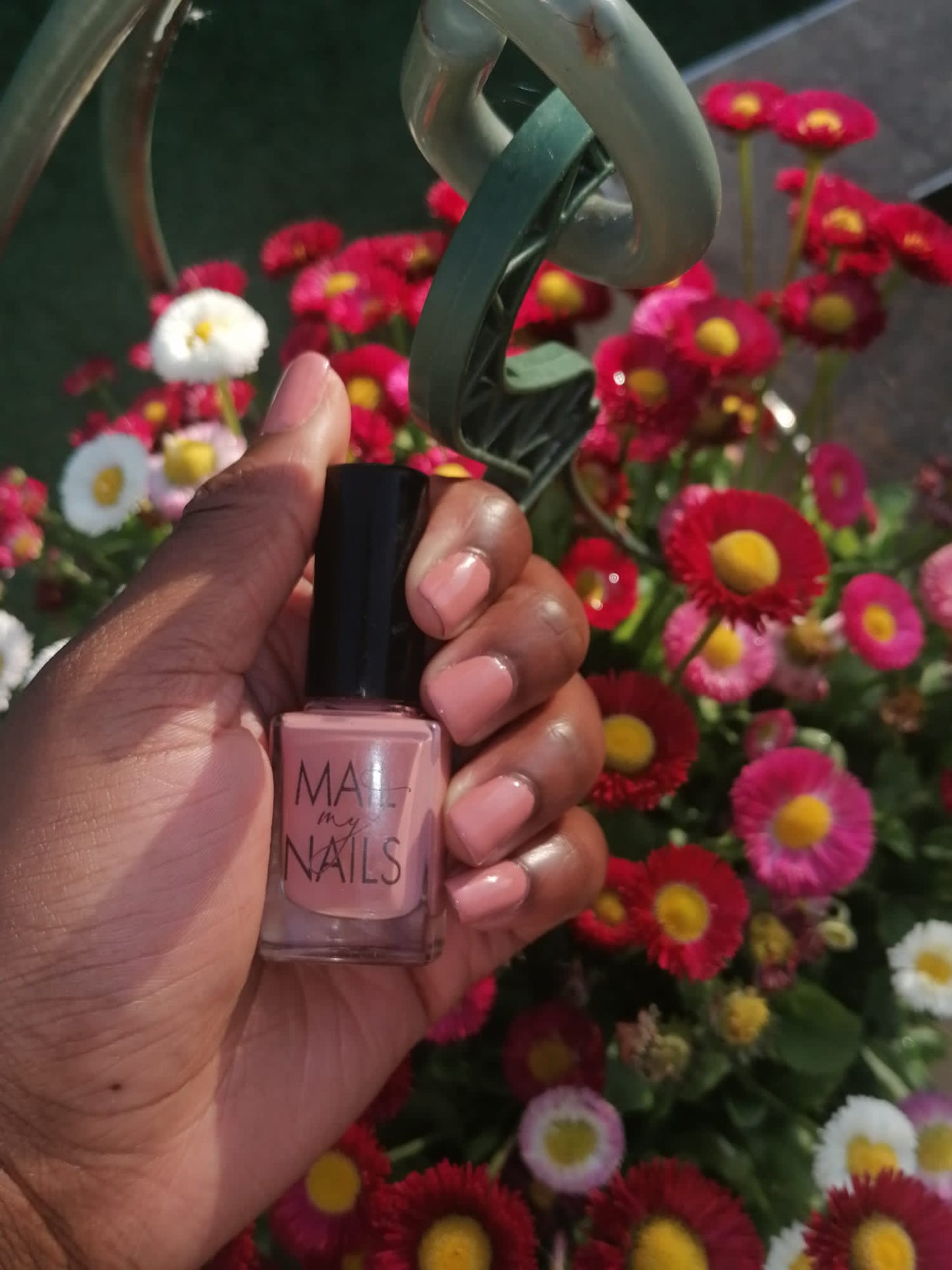 Swatch of peach nude nail polish by flowers