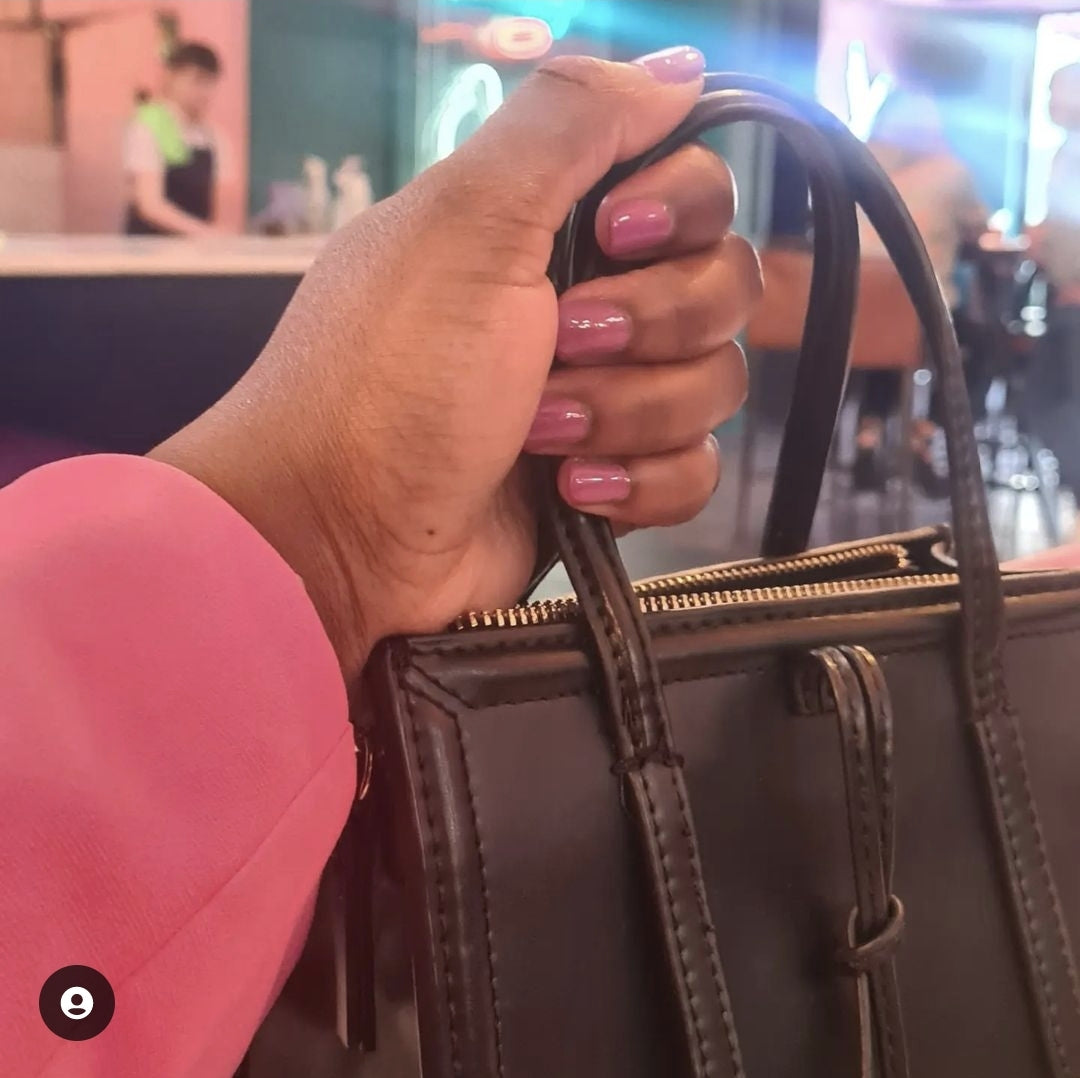 Holding Handbag wearing Pink Gel-Like Nail Polish
